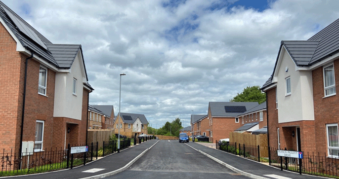 A newly built housing estate with a road up the middle