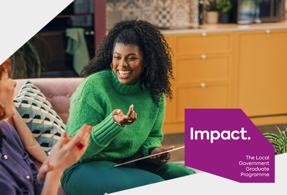 female graduate sitting on a sofa talking to a colleague