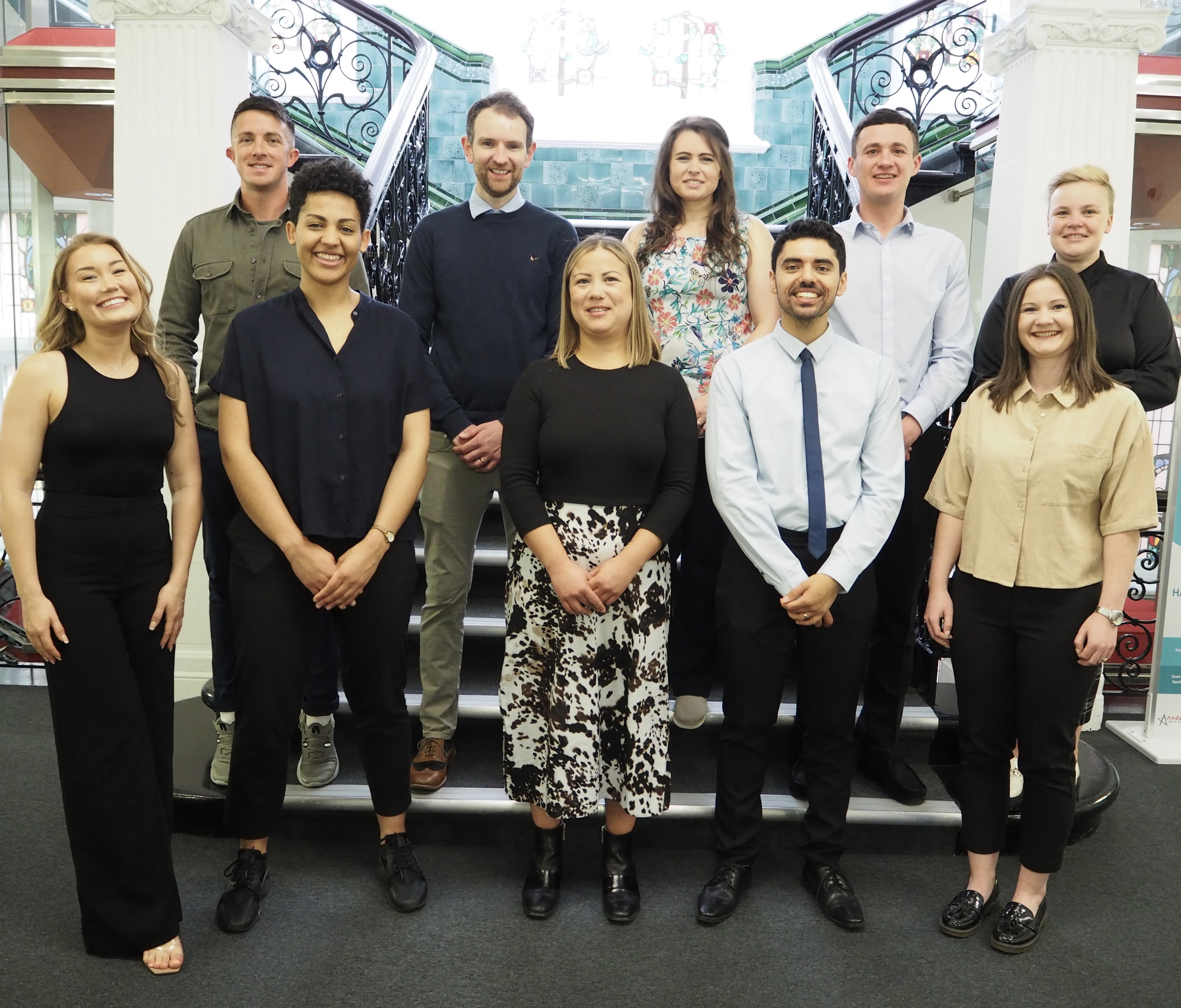 Nine members of the LG Challenge 2023 cohort standing on some town hall steps and smiling