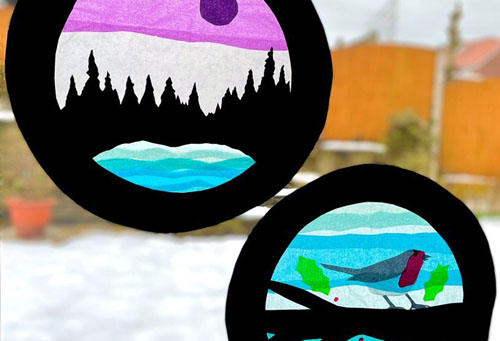 window with round transparent pictures one of landscape with trees and one with a robin in a tree
