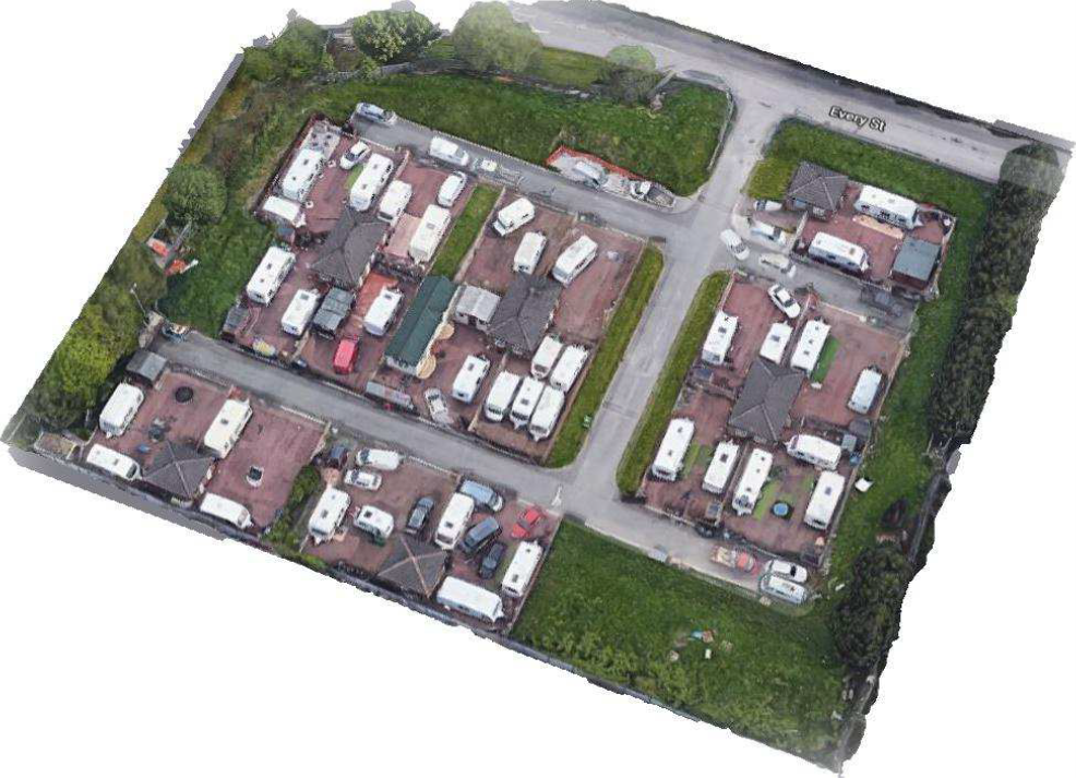 Arial photo of old site layout where multiple white caravans are crowded around the small brick structures