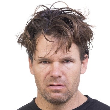 stern-looking man with unkempt hair