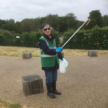 Woman volunteer litter picking in park