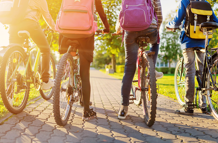 children with their rucksacks on bikes