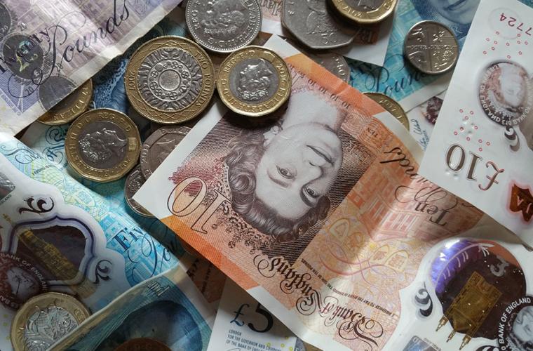 Pile of money (pounds sterling) including notes and coins