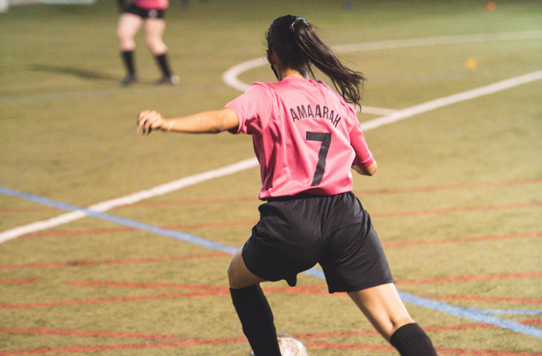 Girl playing football on local leisure centre