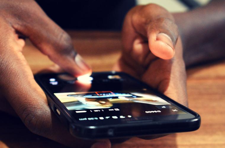 Hands holding a mobile phone indoors 