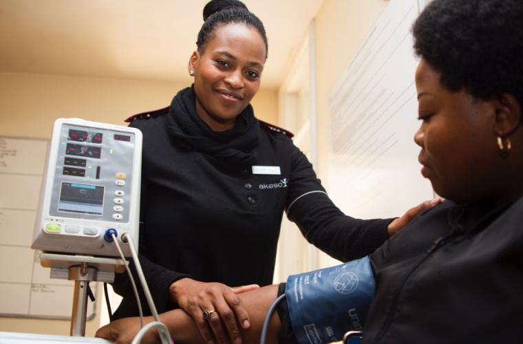 Nurse taking blood pressure of woman