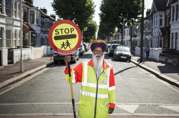 Man with a stop sign at a school crossing