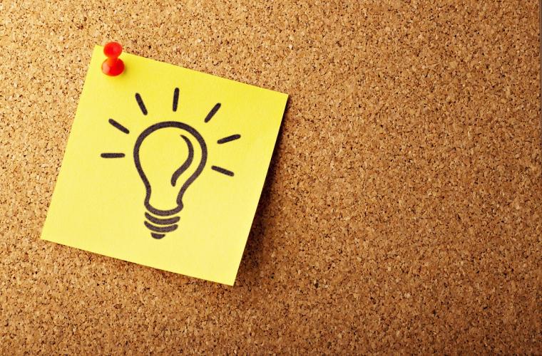 Lightbulb drawing on a sticky note stuck to a board