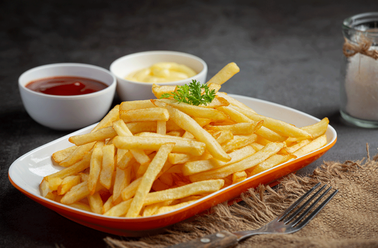 A plate full of chips with ketchup and mayo on the back 