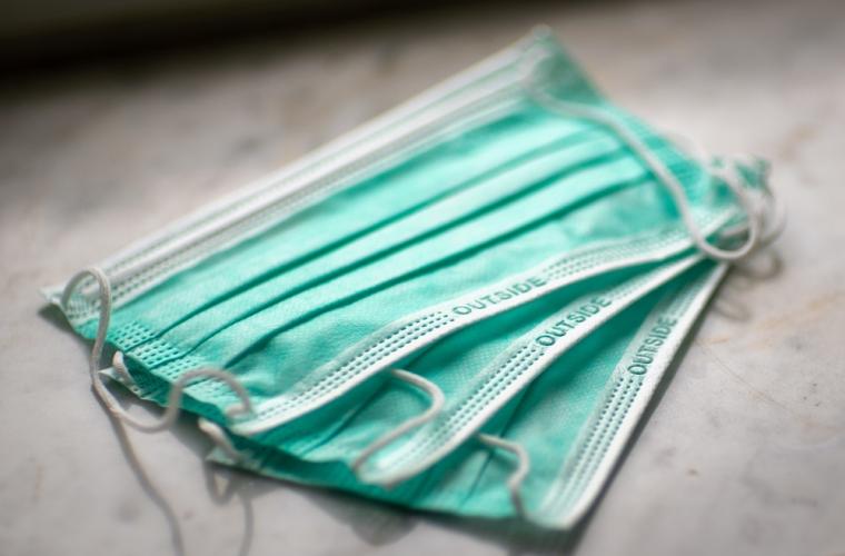 Three green surgical face masks on a table