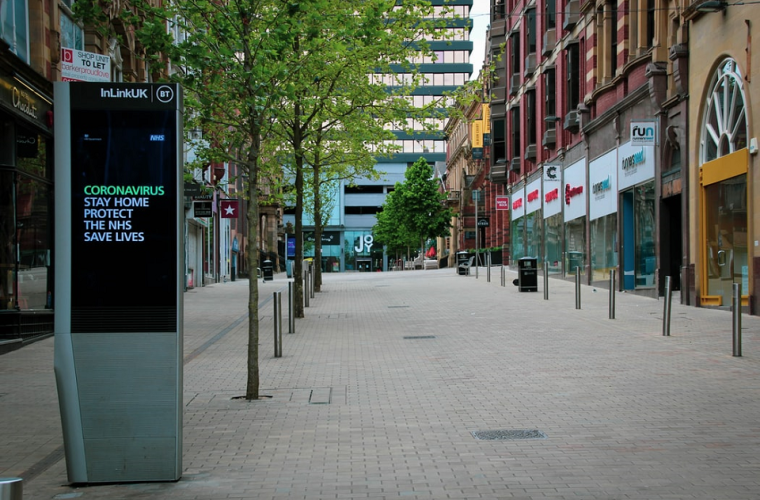An empty town high street with a coronavirus interactive poster in the street
