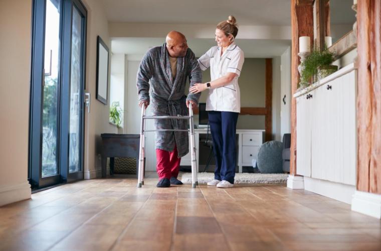 Nurse helping patient take steps in aftercare