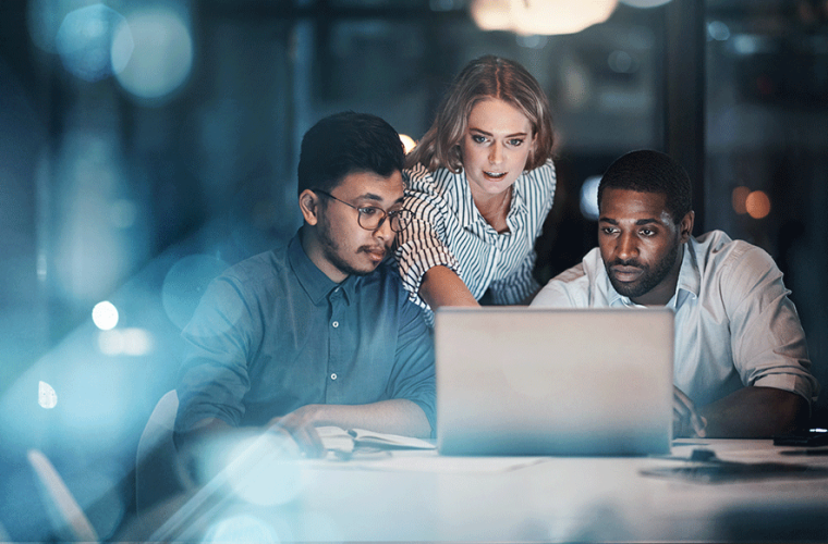 Three people working digitally in a office space