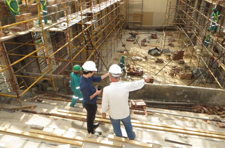 House under construction with two people debating on a certain aspect of the design