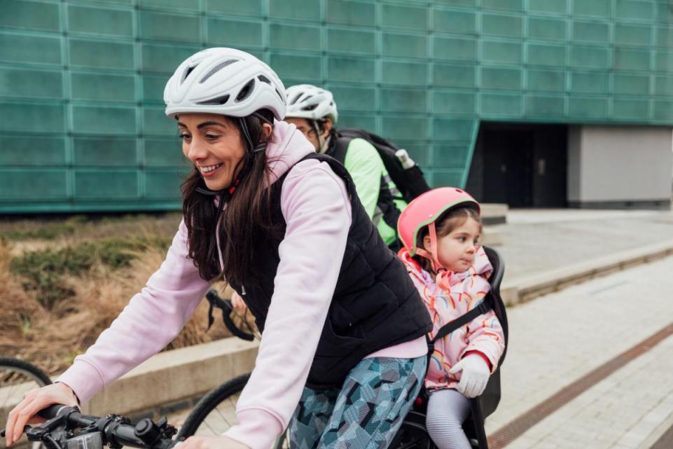 Mother and child on a bicycle wearing helmets
